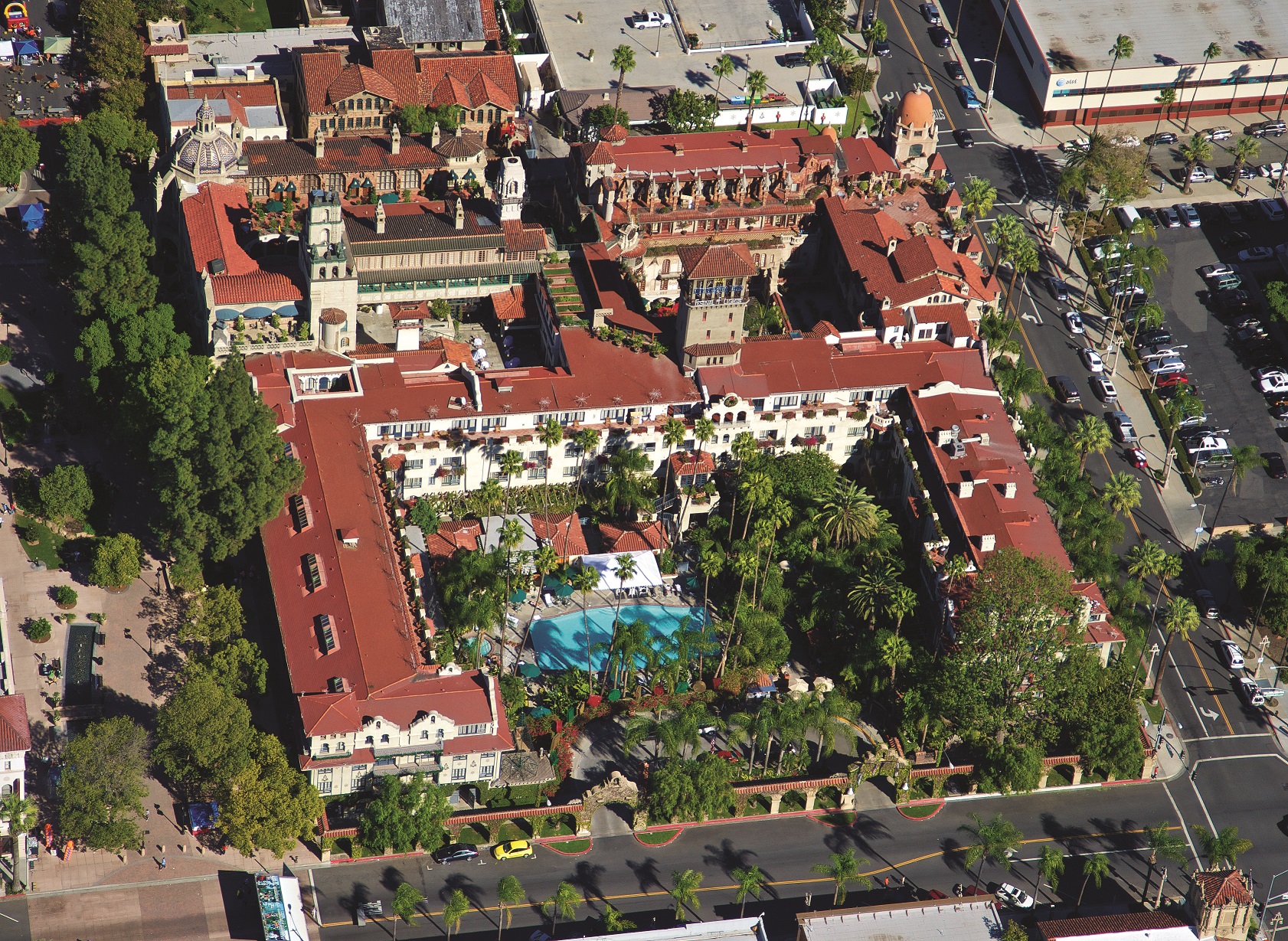 an aerial view of a large building with a pool in the middle