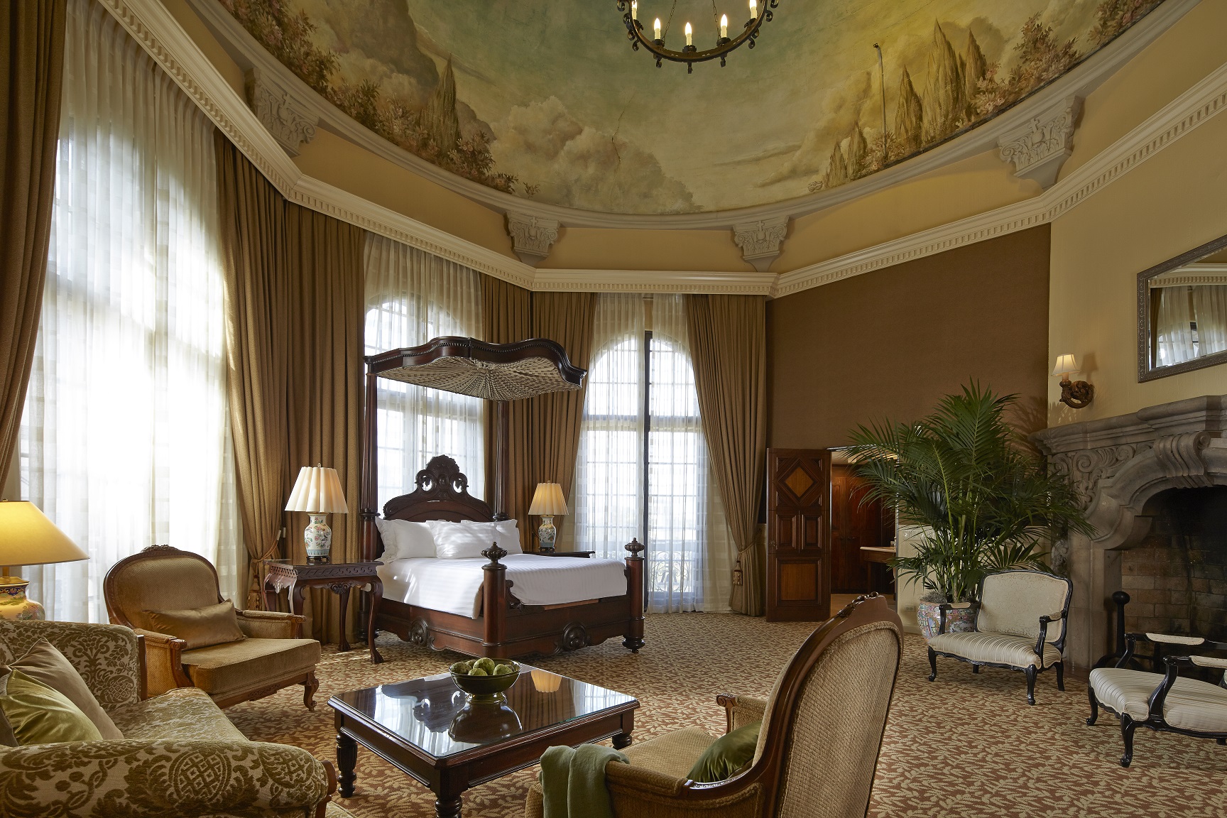 a room with a bed and chairs