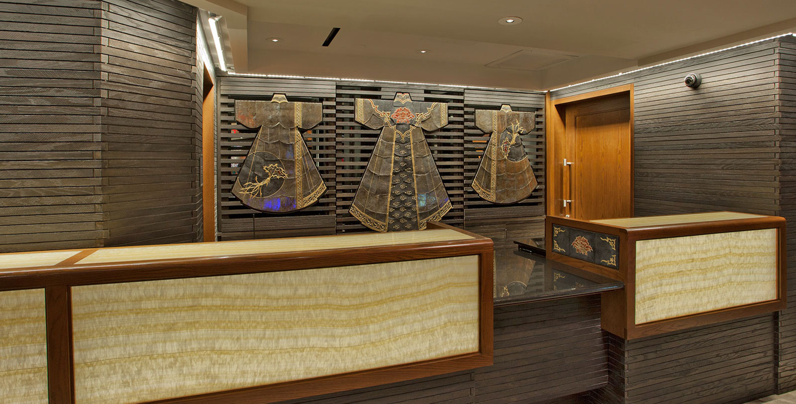 a room with a reception desk and art on the wall