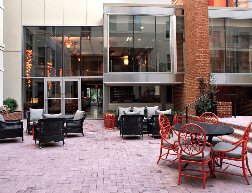 a patio with chairs and tables outside of a building