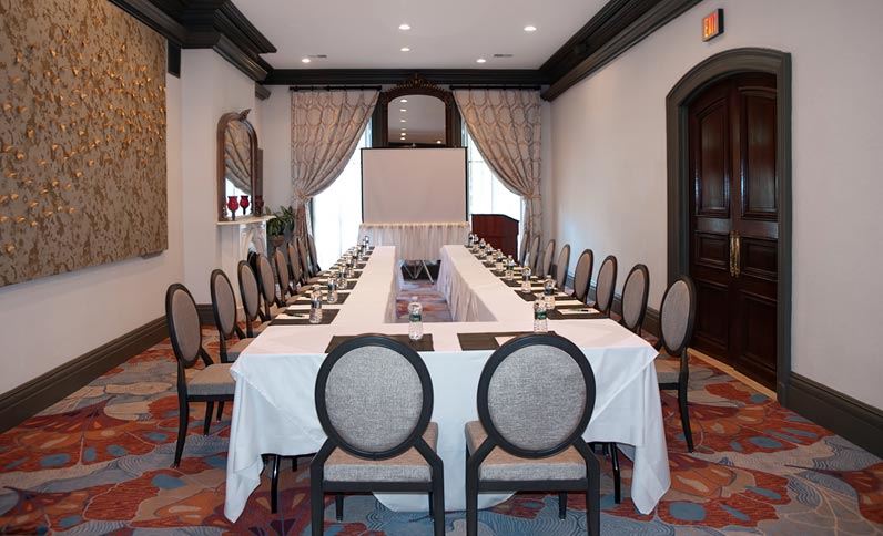 long table with white tablecloths and chairs in a room