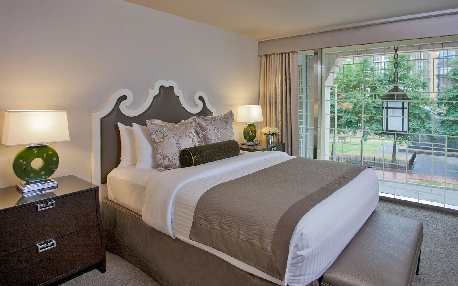 a bed with a white headboard and brown pillows