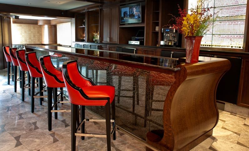 a bar with red chairs and a vase of flowers
