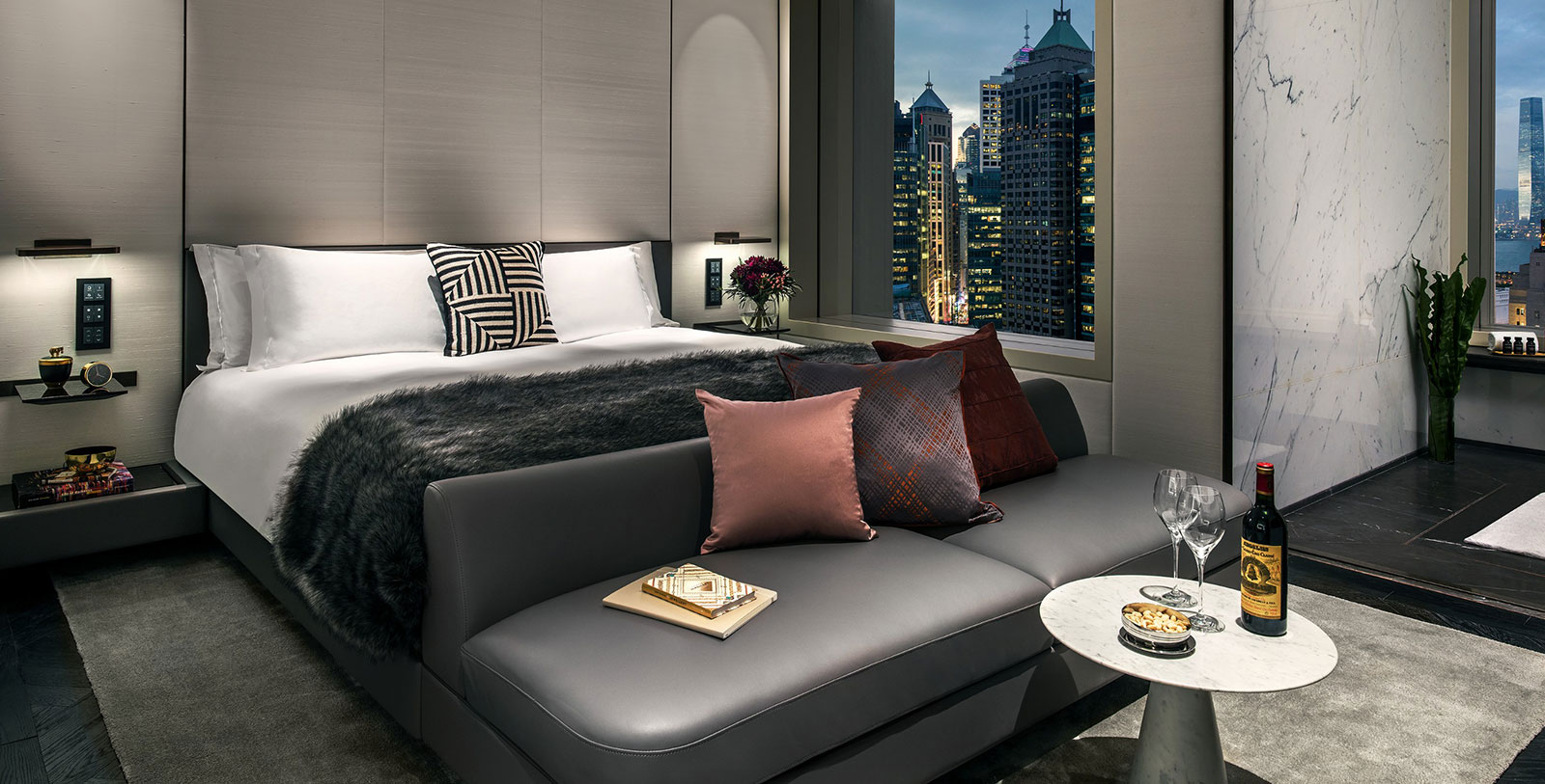 a bed with pillows and a table in front of a window
