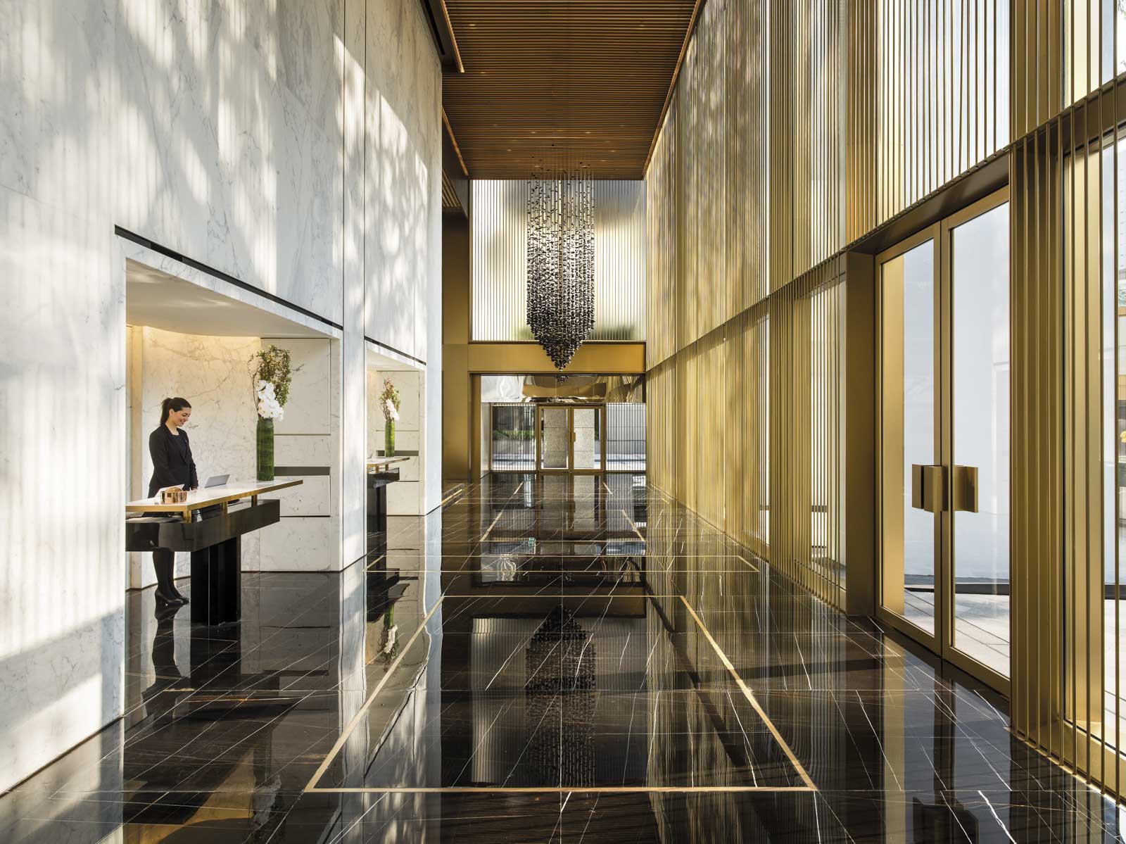 a woman standing at a desk in a lobby