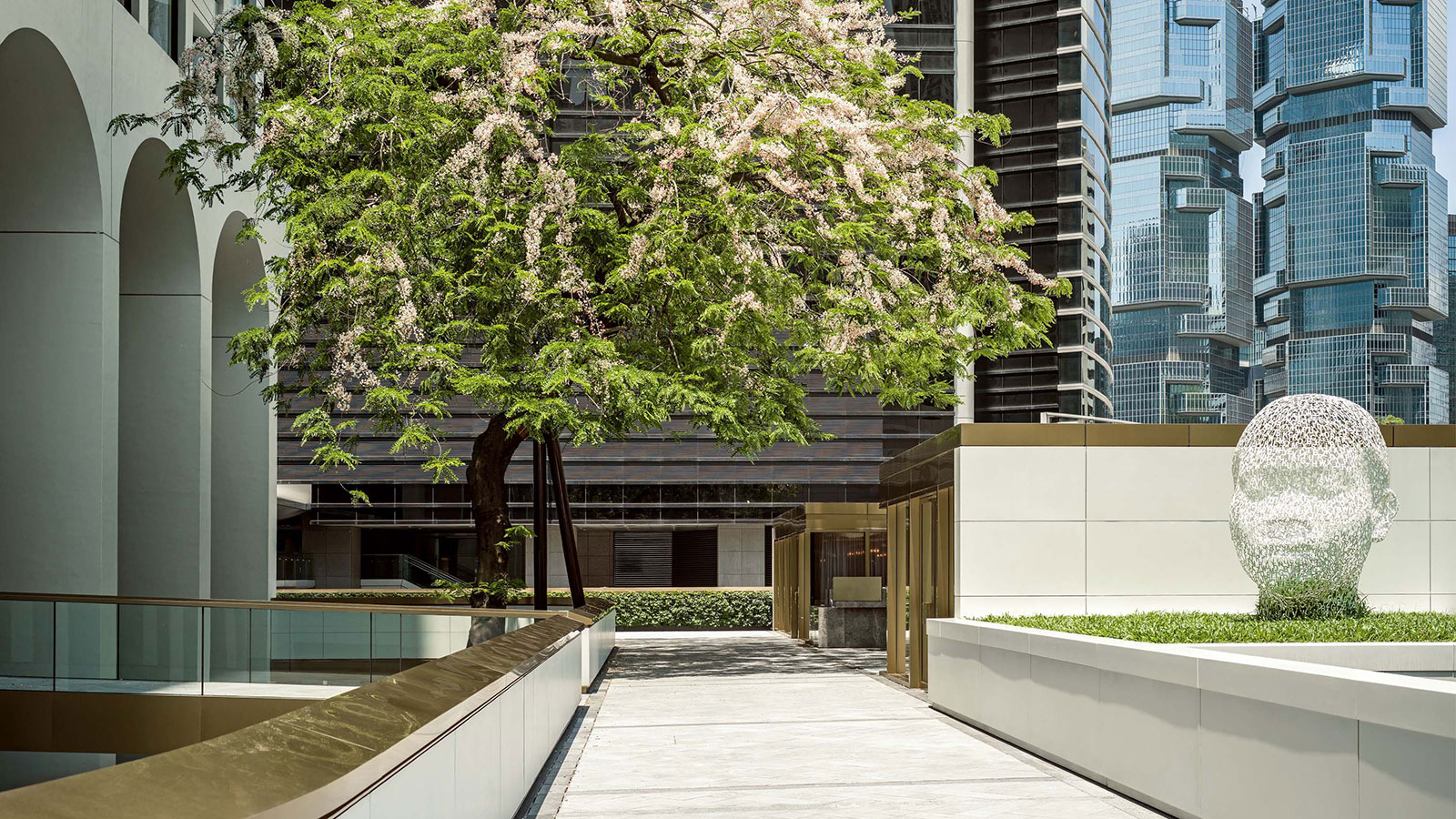 a walkway with trees and a building in the background