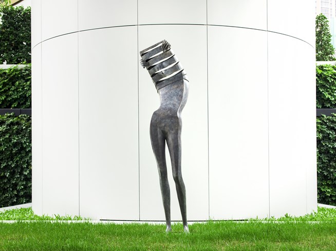 a statue of a woman standing on grass
