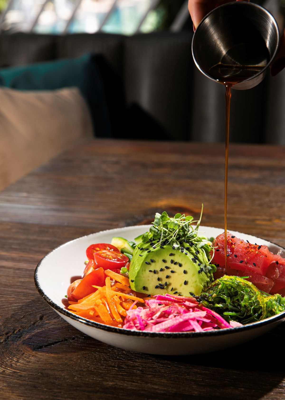 a bowl of food with a sauce being poured onto it