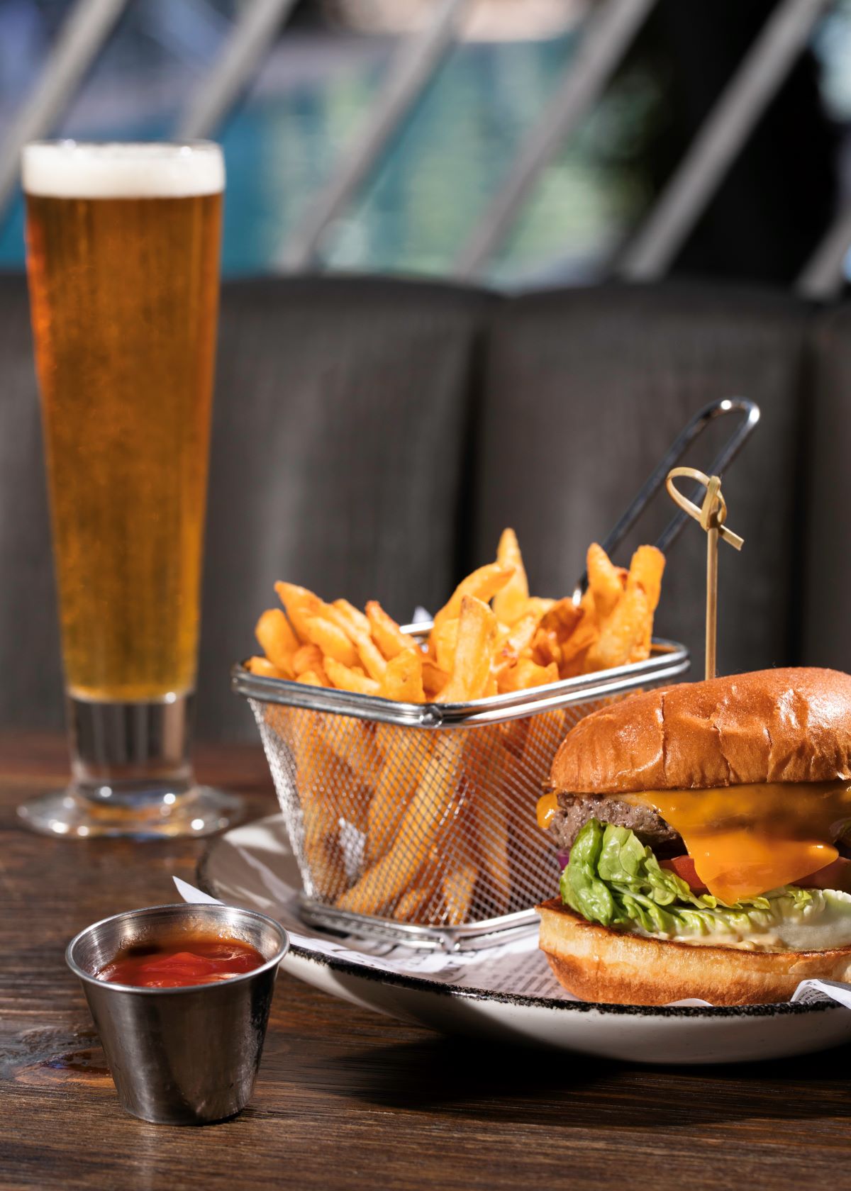 a burger and fries on a plate with a glass of beer