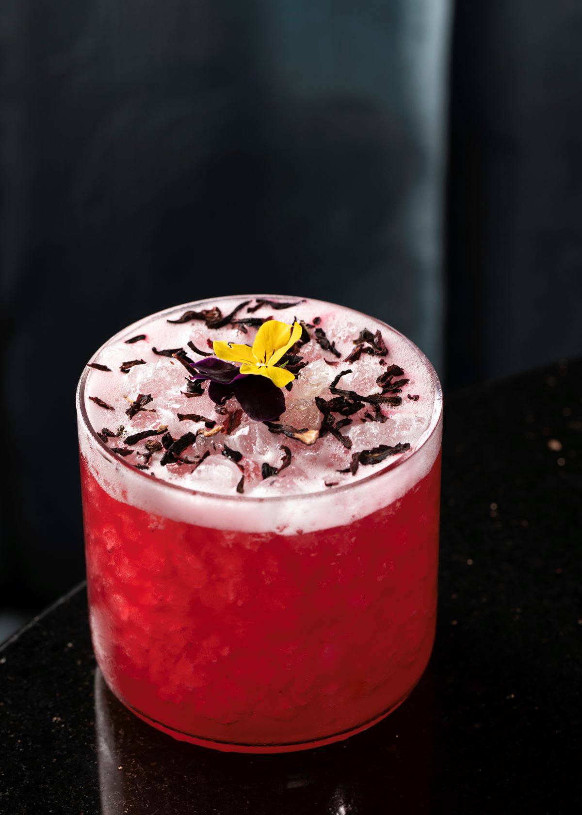 a glass with a drink and a flower on top