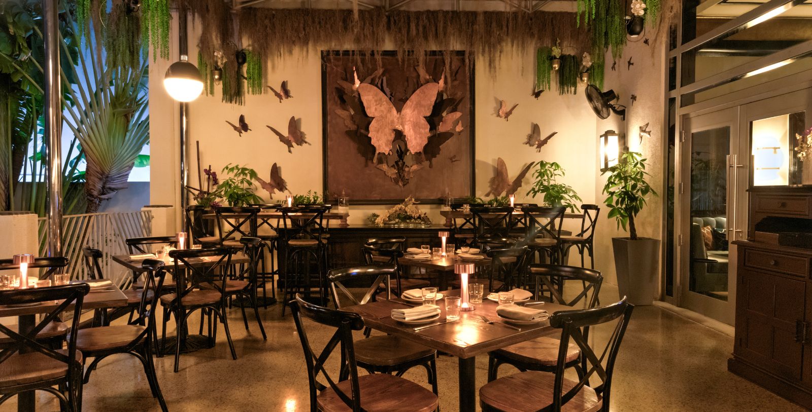 a room with tables and chairs and butterflies on the wall