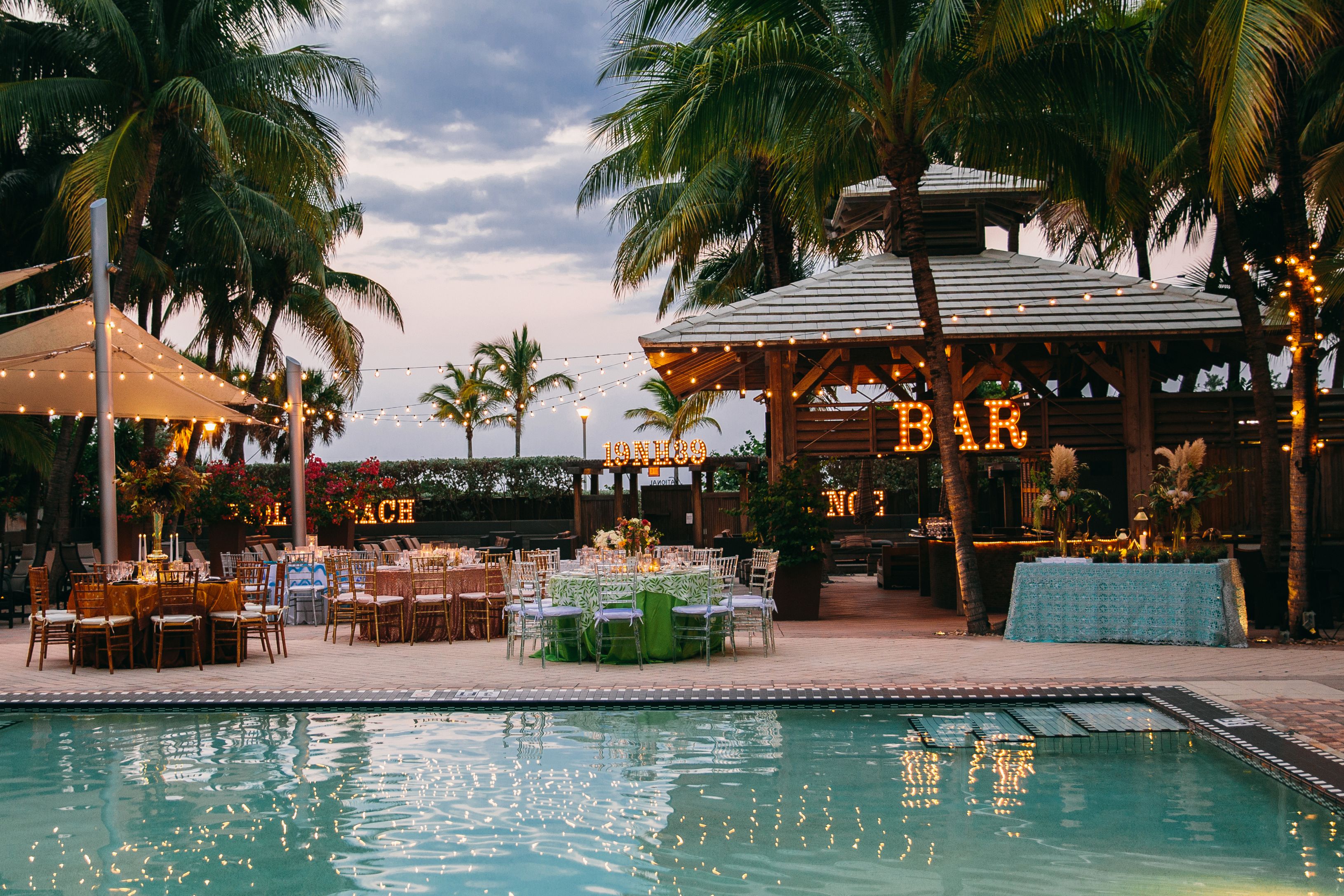 a pool with tables and chairs and a gazebo