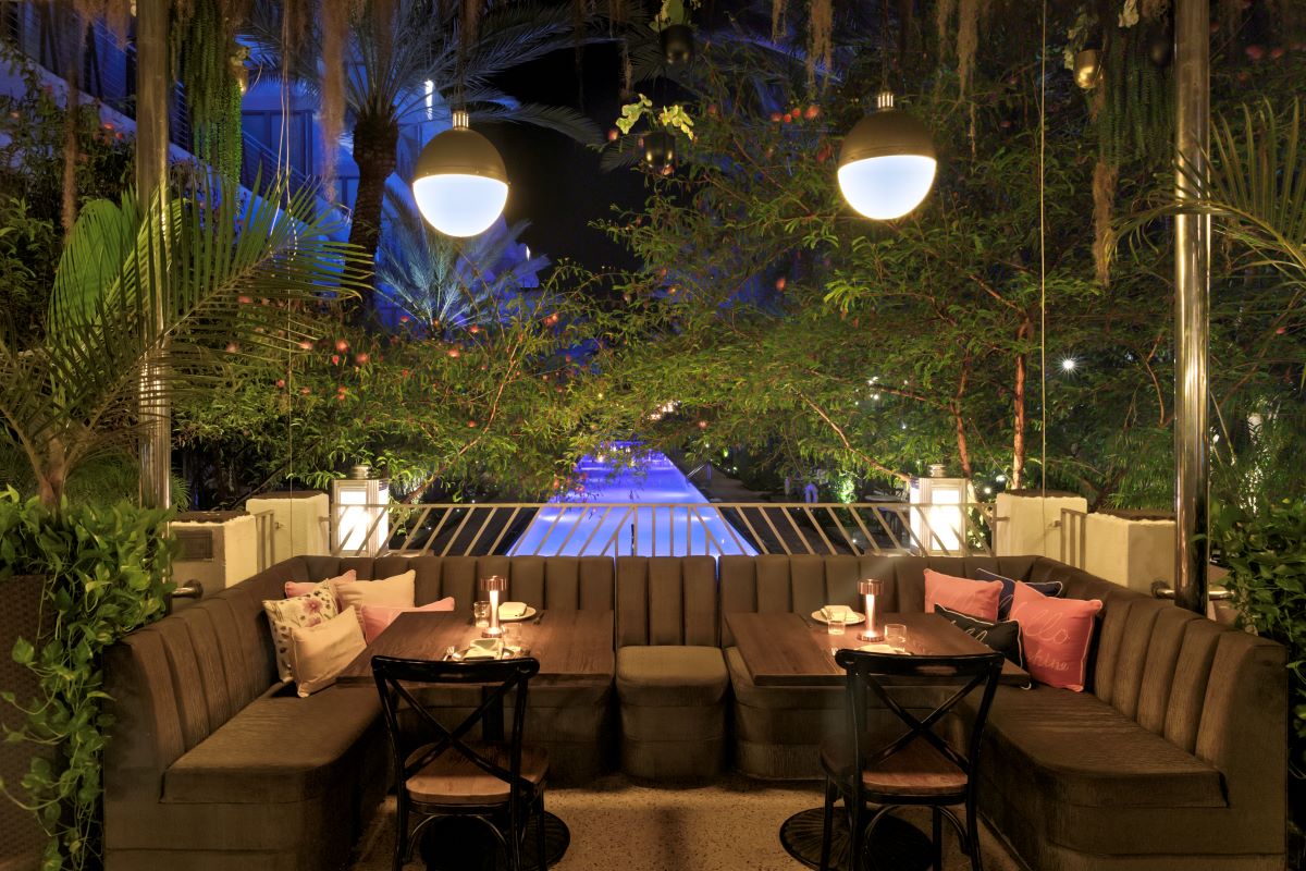 a outdoor seating area with a pool in the background