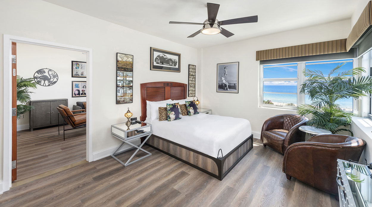 a bedroom with a large bed and a leather chair