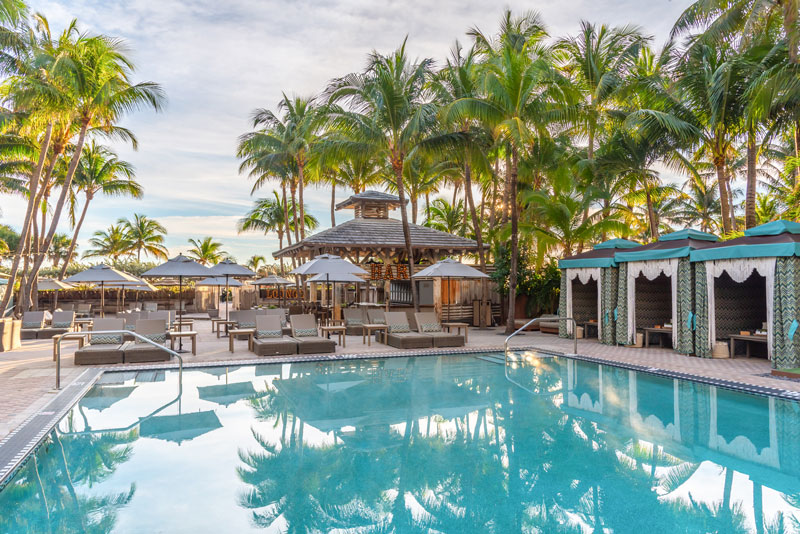 a pool with lounge chairs and umbrellas