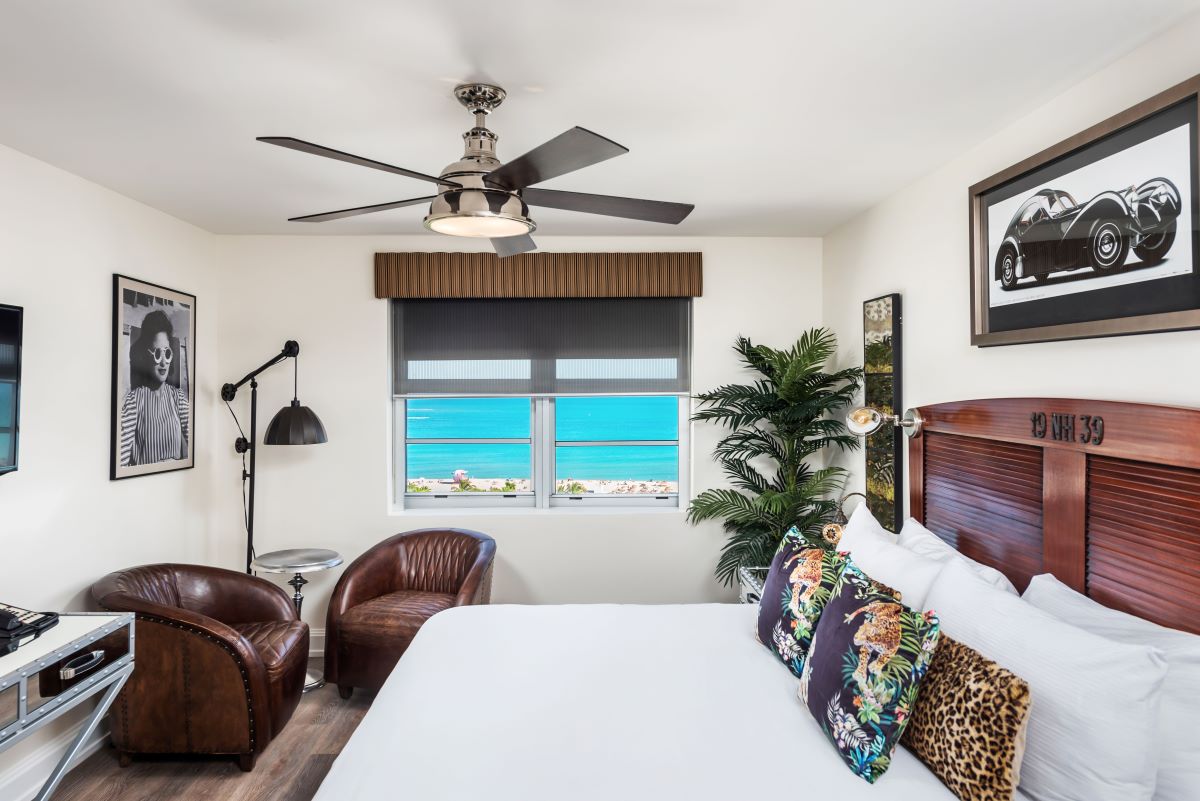 a room with a bed and chairs