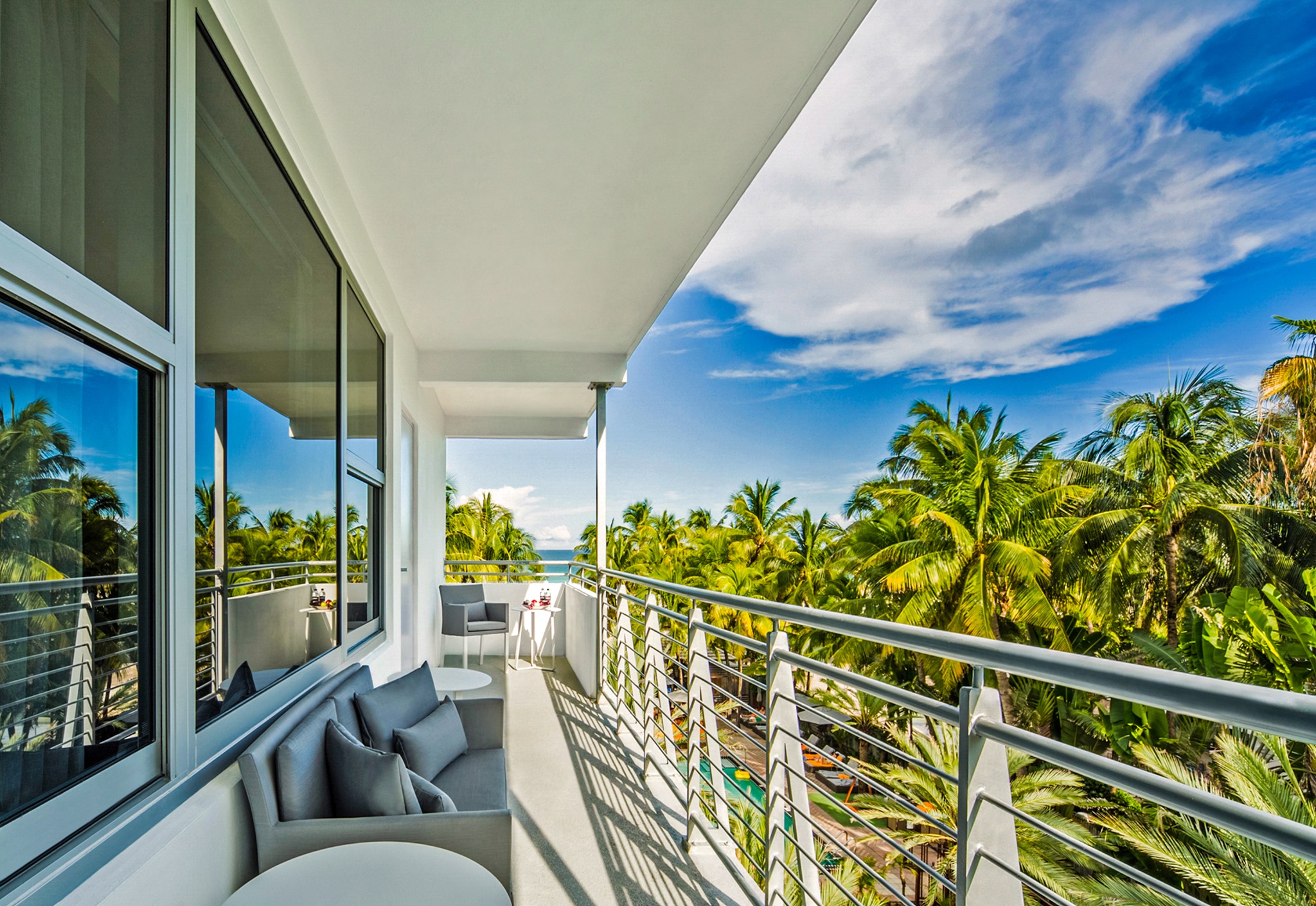 a balcony with palm trees and a blue sky