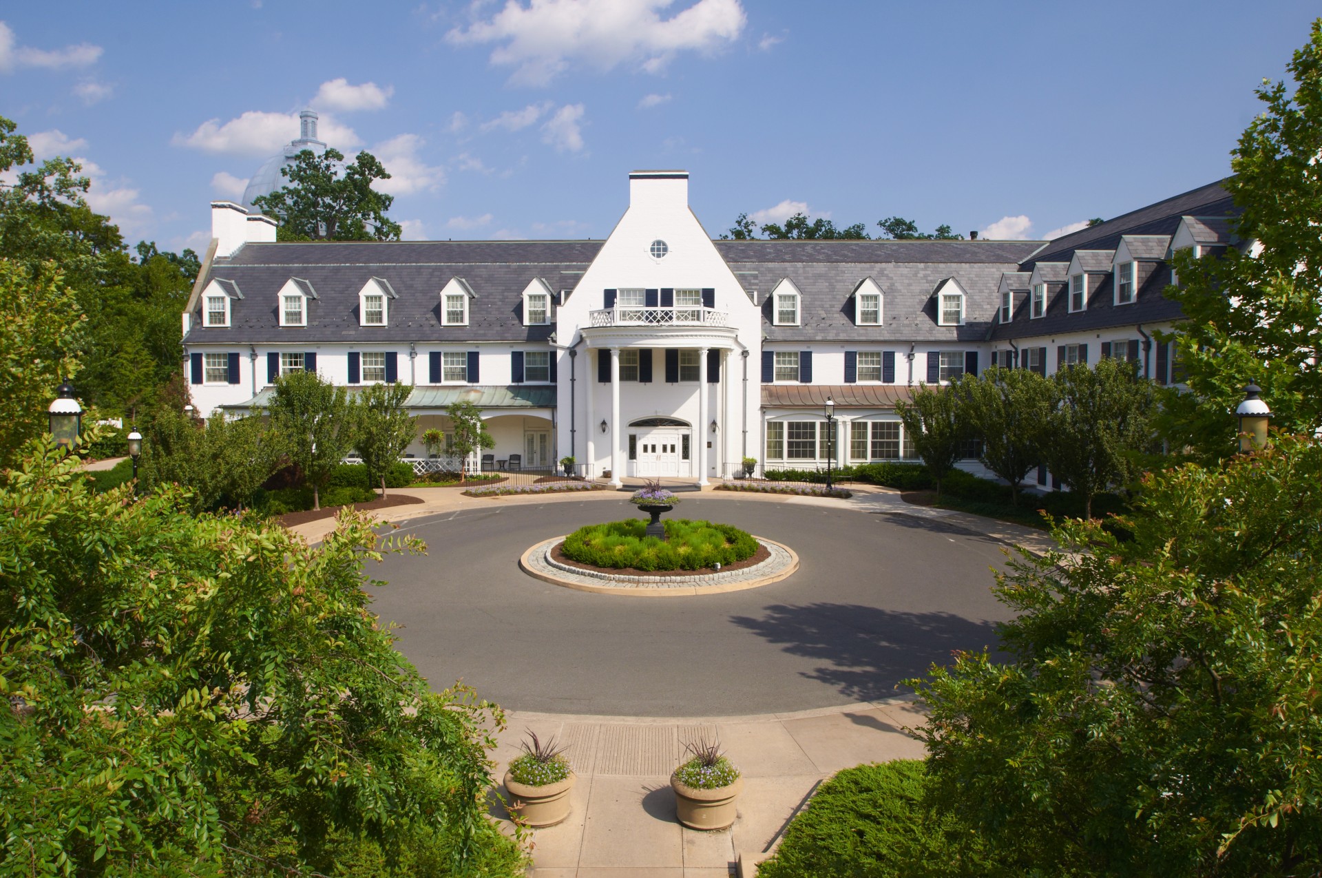 a large white building with a circular fountain in front of it