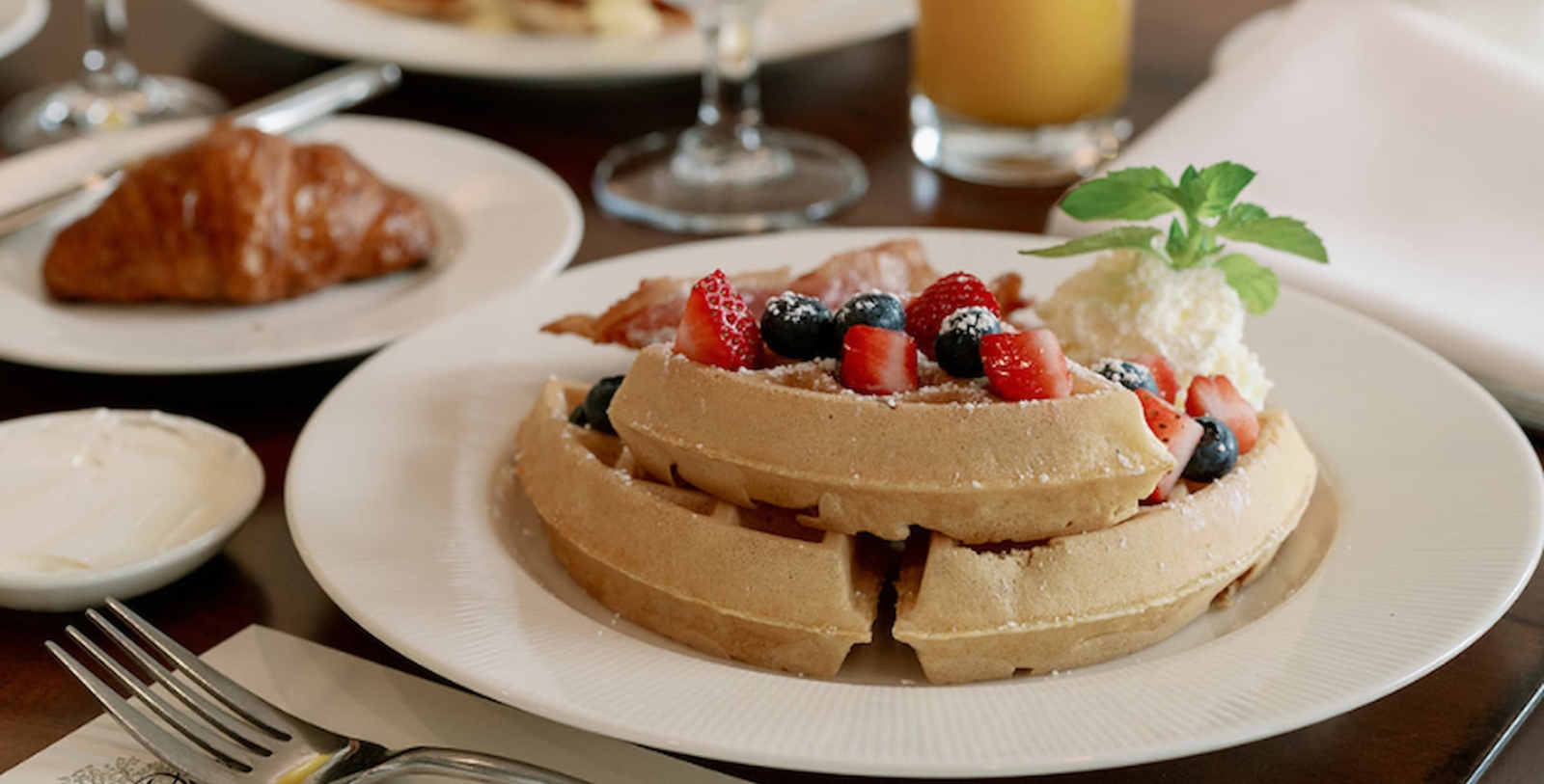 a plate of waffles with strawberries and blueberries