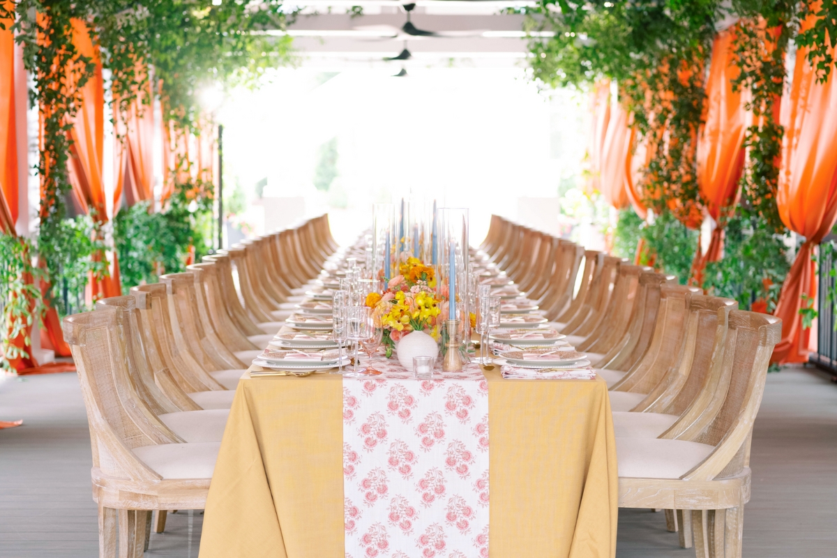 a long table set with chairs and flowers