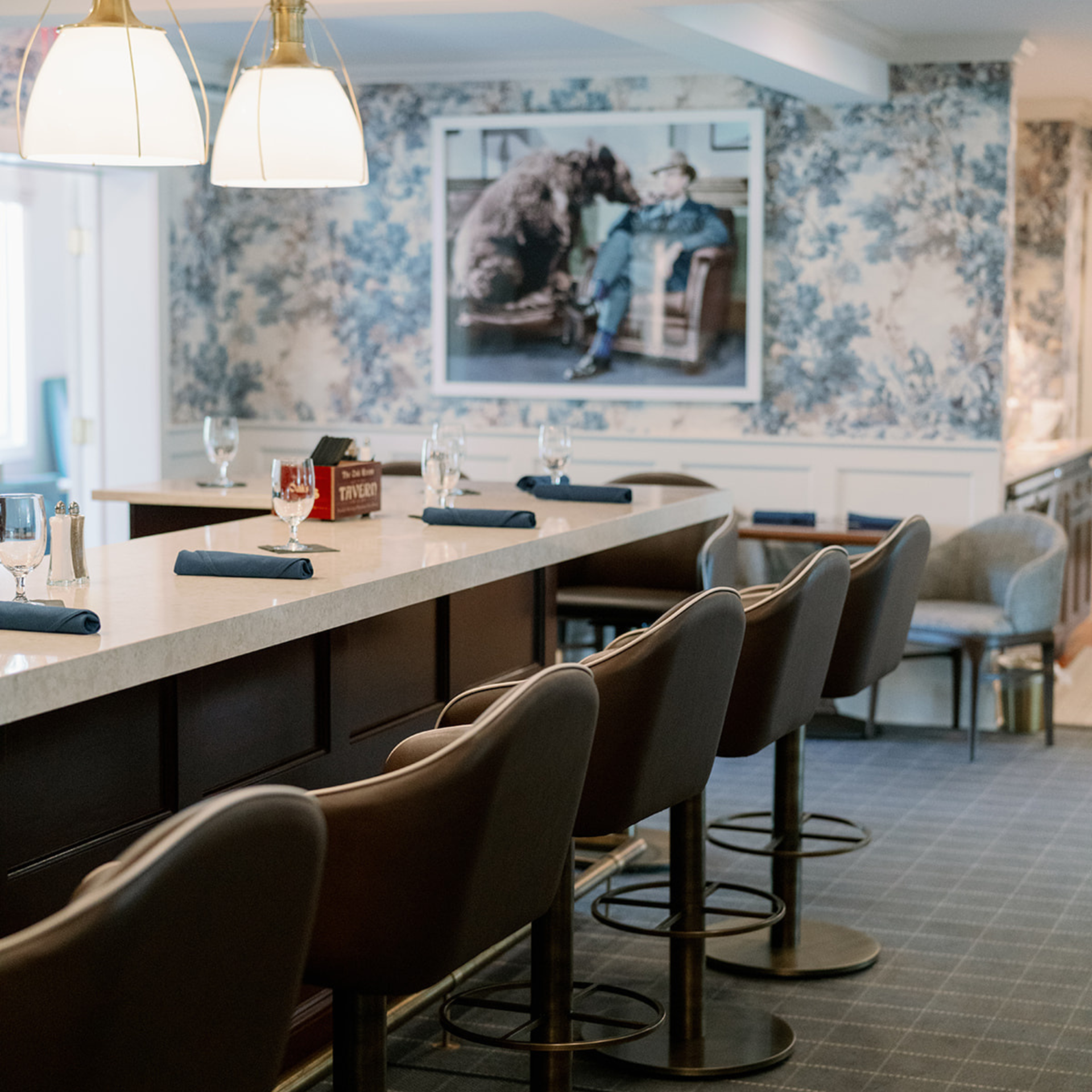 a bar with chairs and a picture on the wall