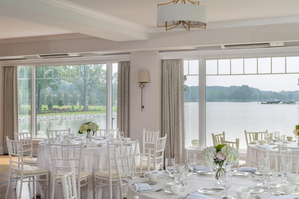 a room with tables and chairs and a lake