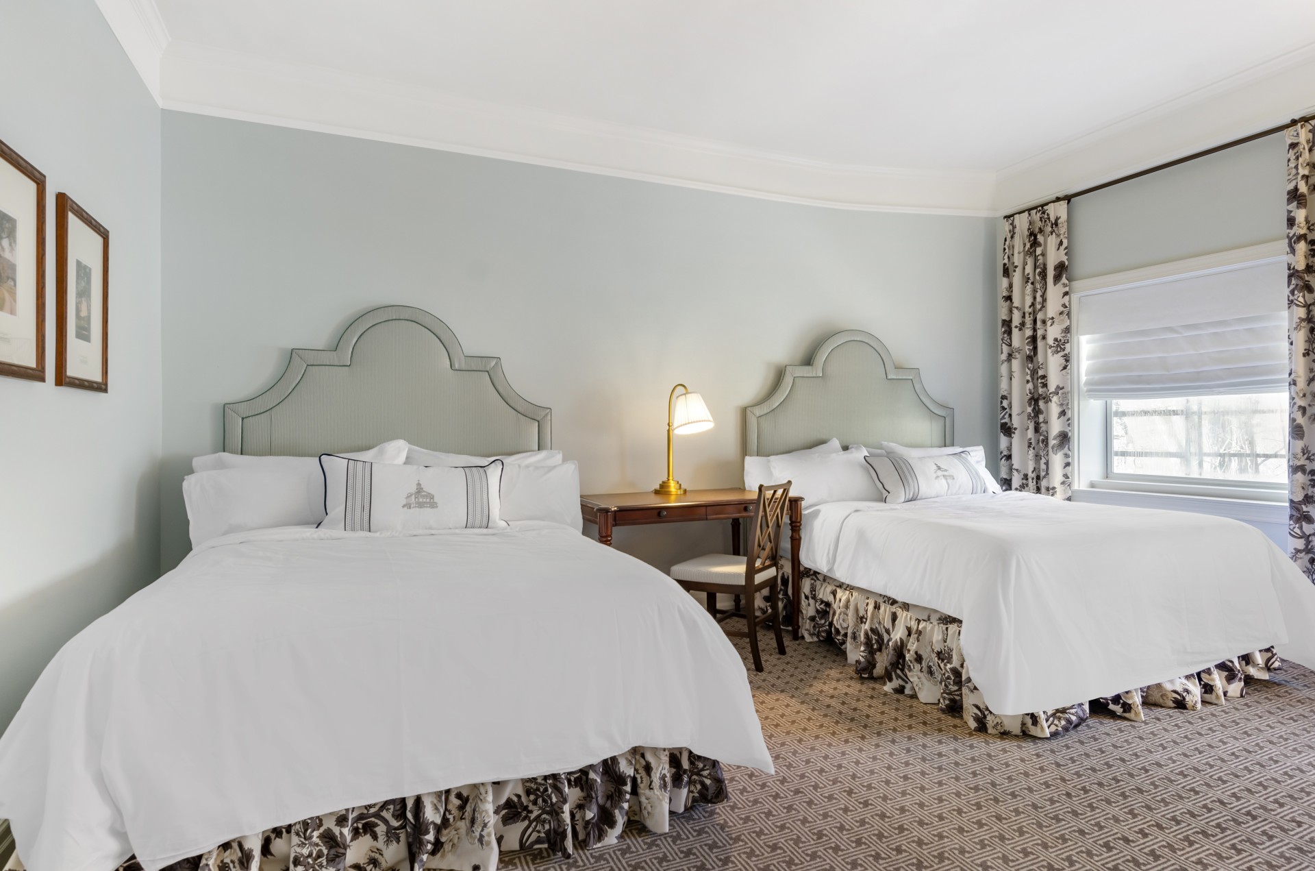 a room with two beds and a desk