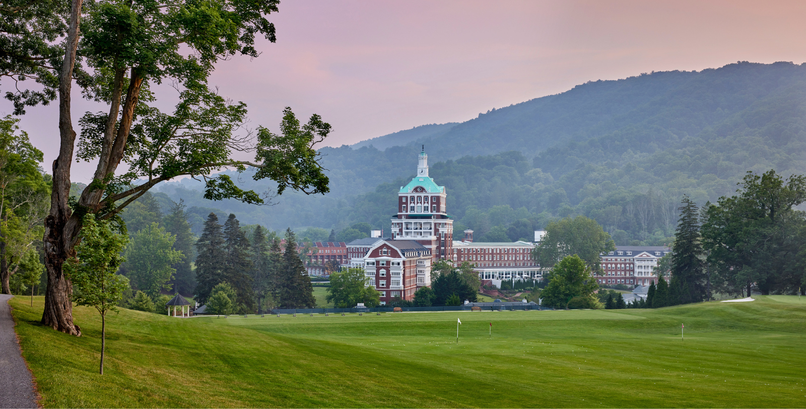 a large building with a golf course in the background