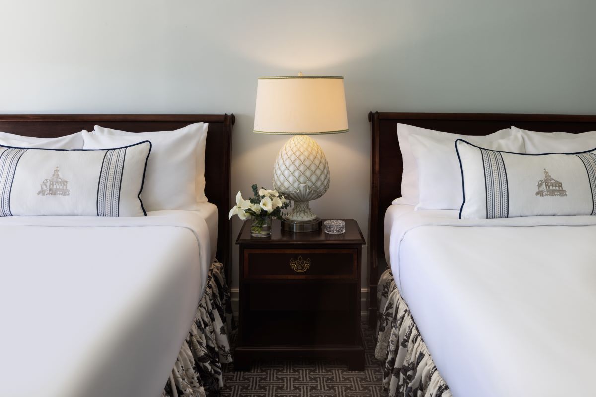 a lamp on a table next to a bed