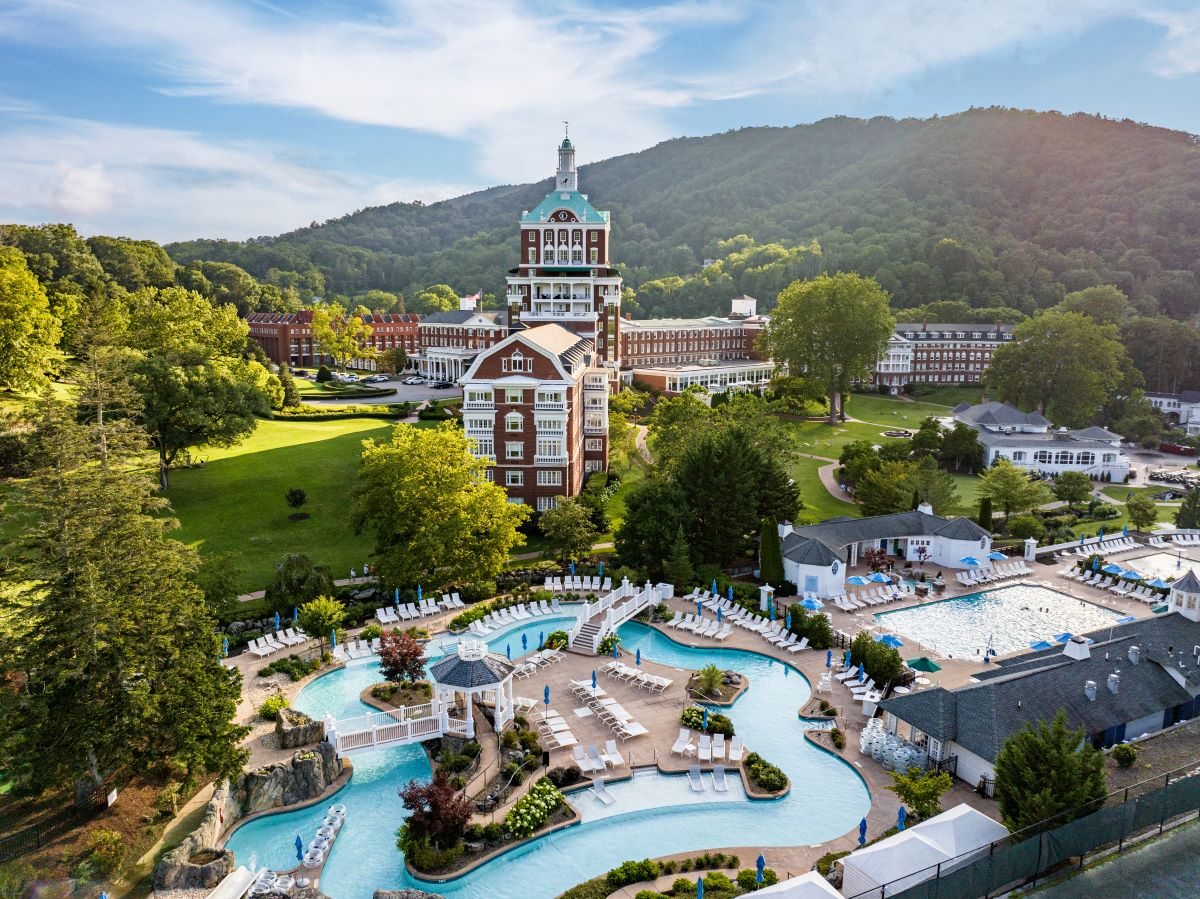 a pool in a resort with The Homestead in the background