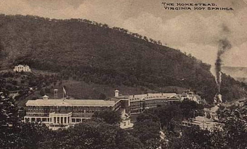 a large building with a hill in the background