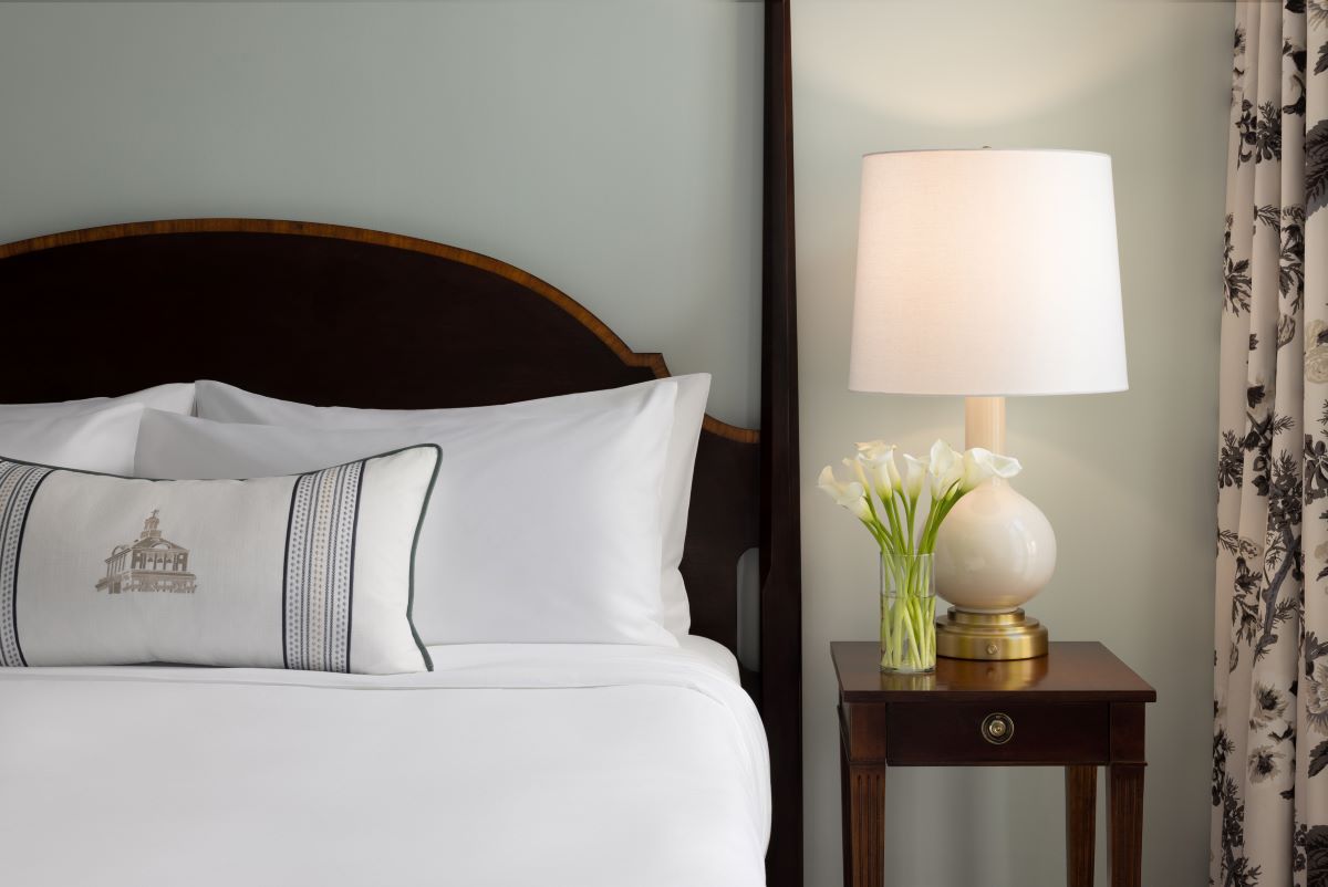 a lamp next to a bed