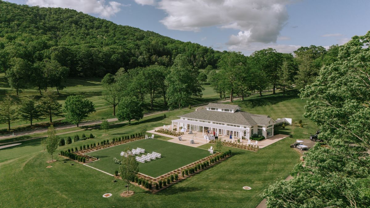 a building with white chairs and a lawn in front of it