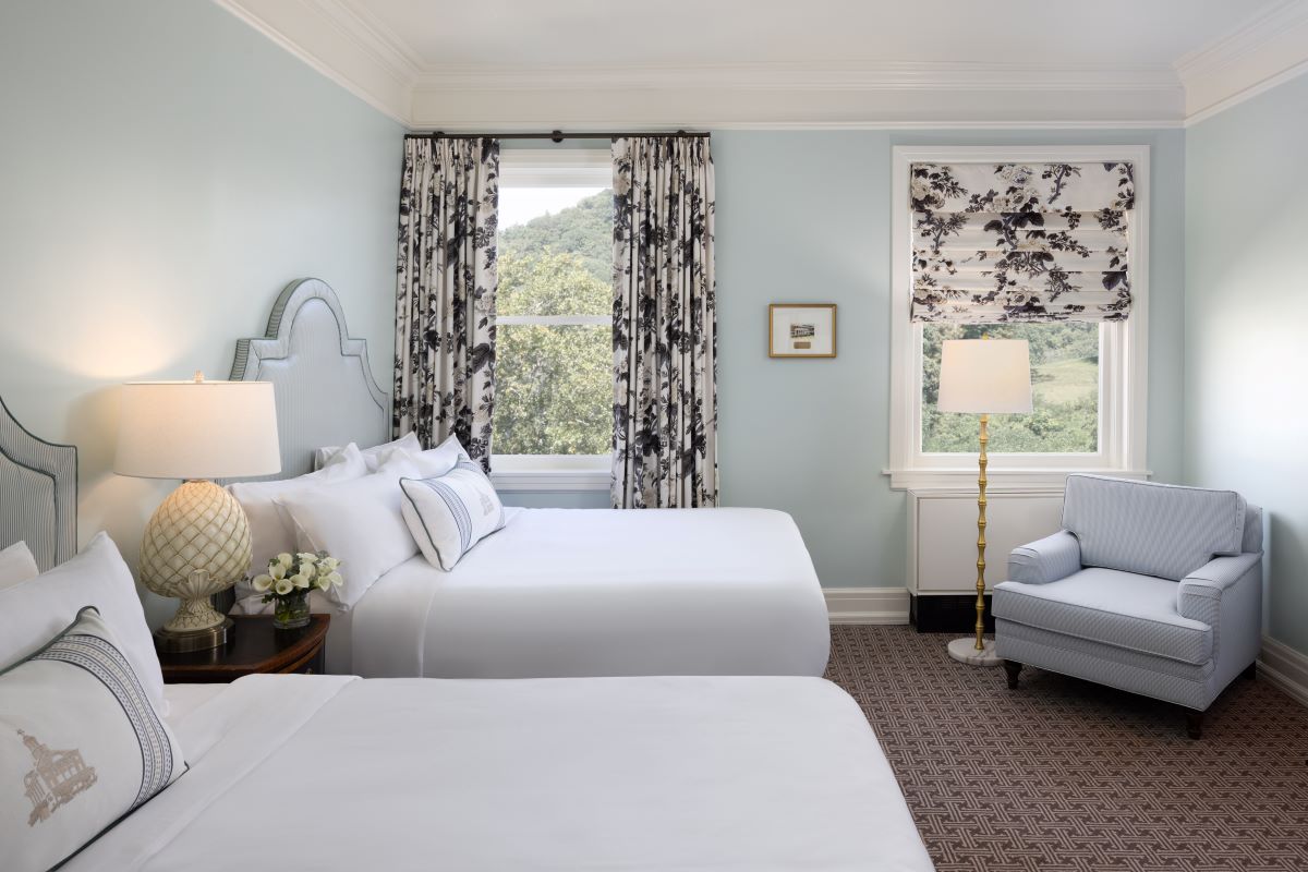 a room with two beds and a chair