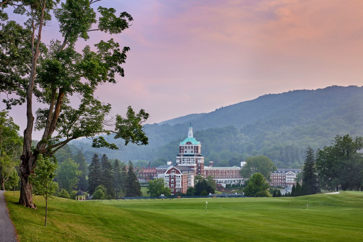 a large building with a large tower and a large green field