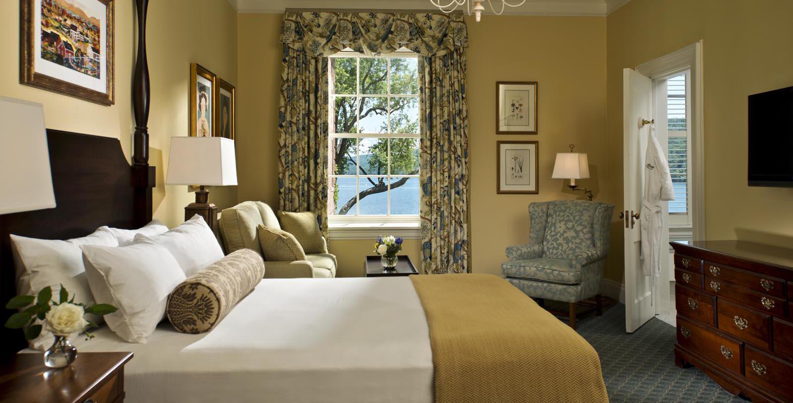 a room with a bed and chairs