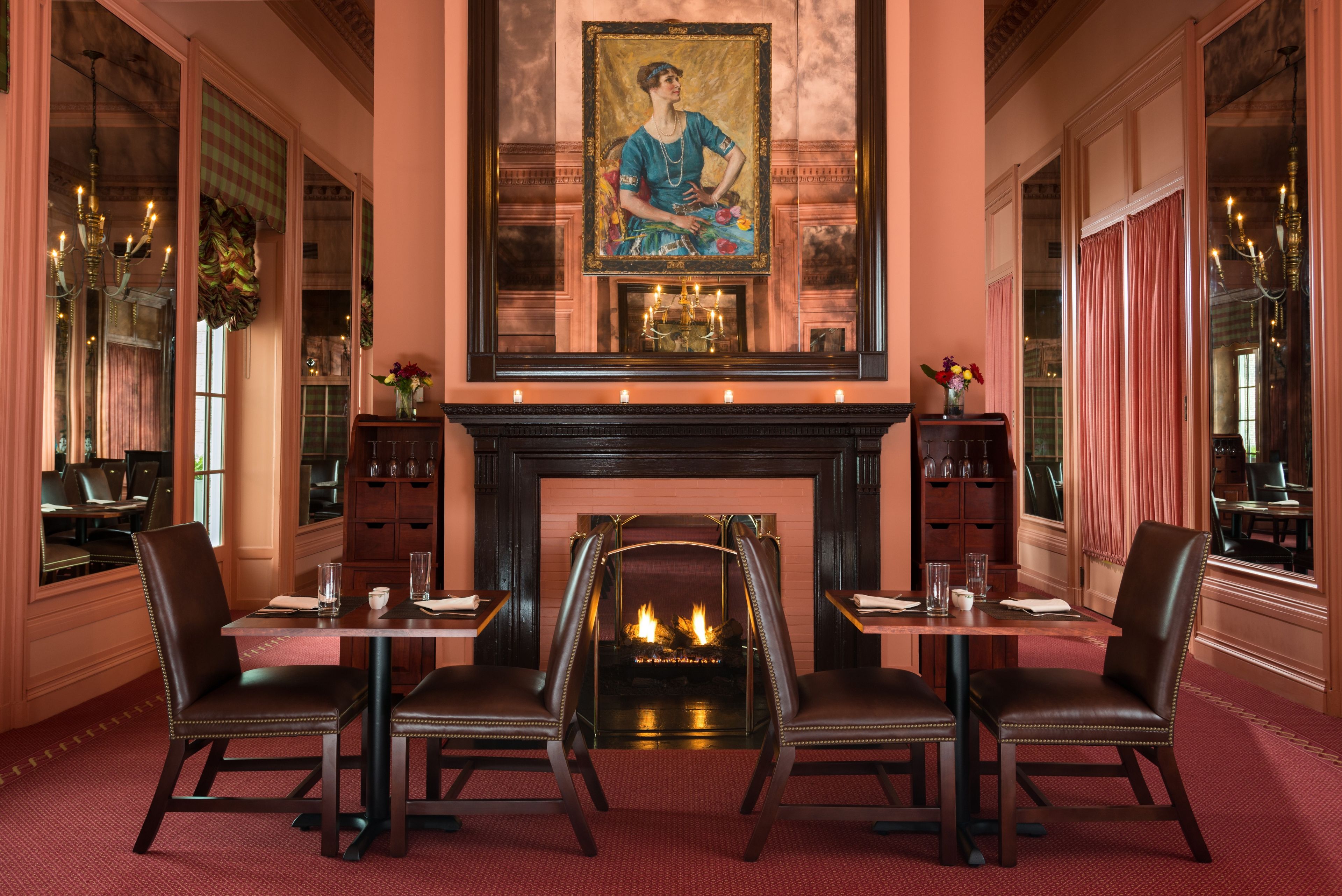 a room with a fireplace and tables and chairs