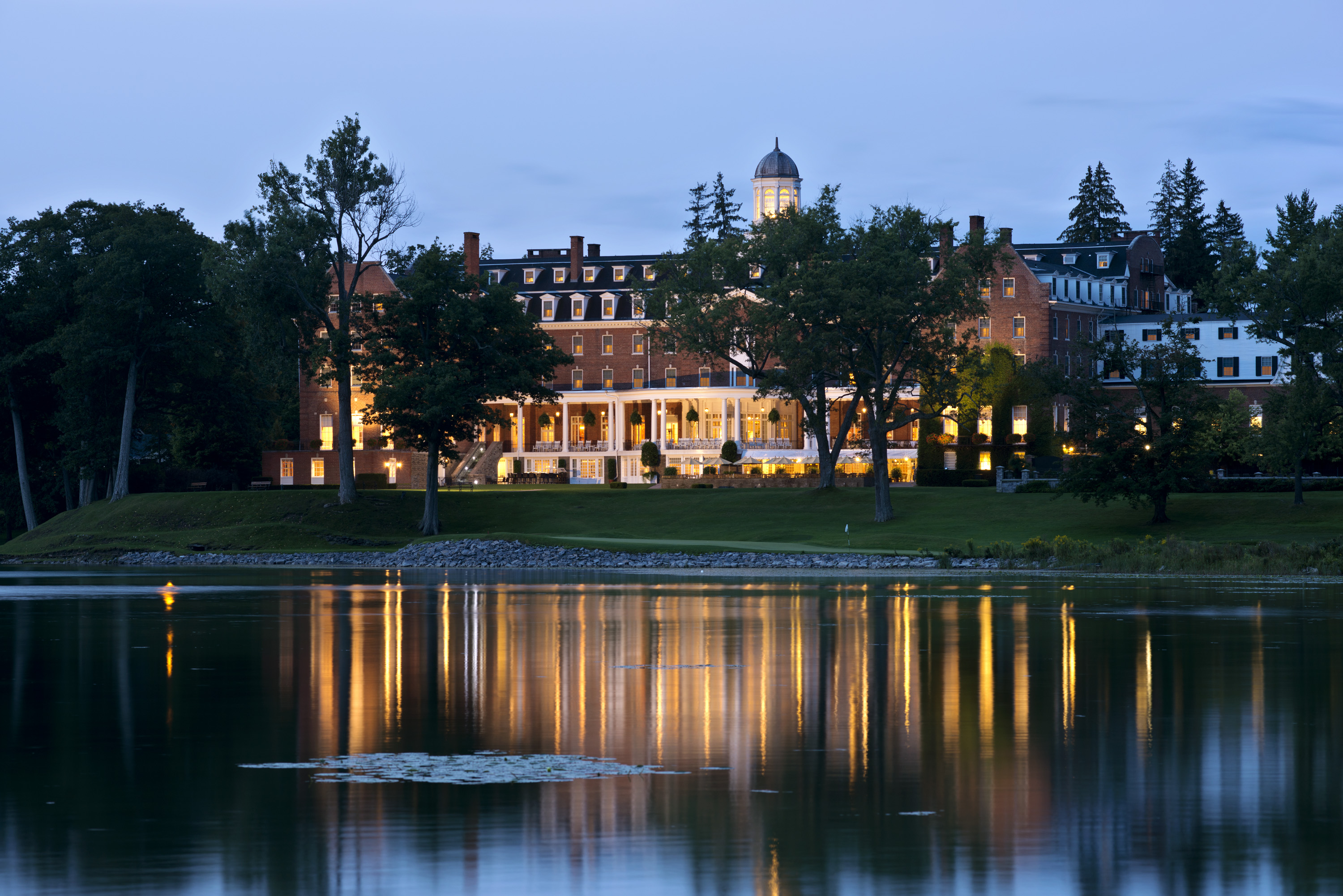 a building with trees and a body of water