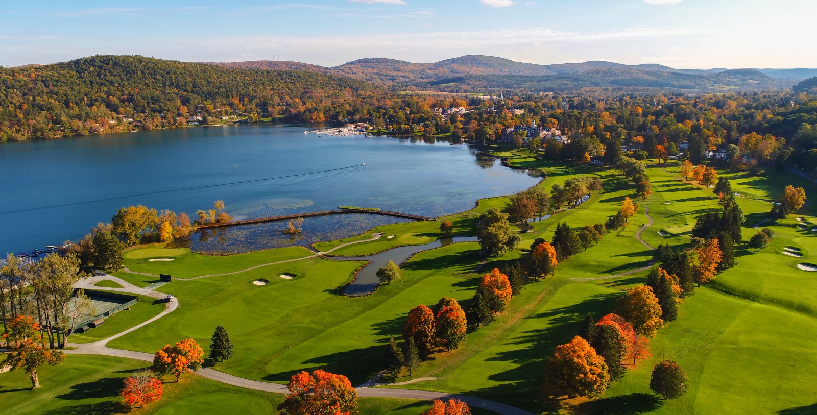 a golf course with a body of water and trees
