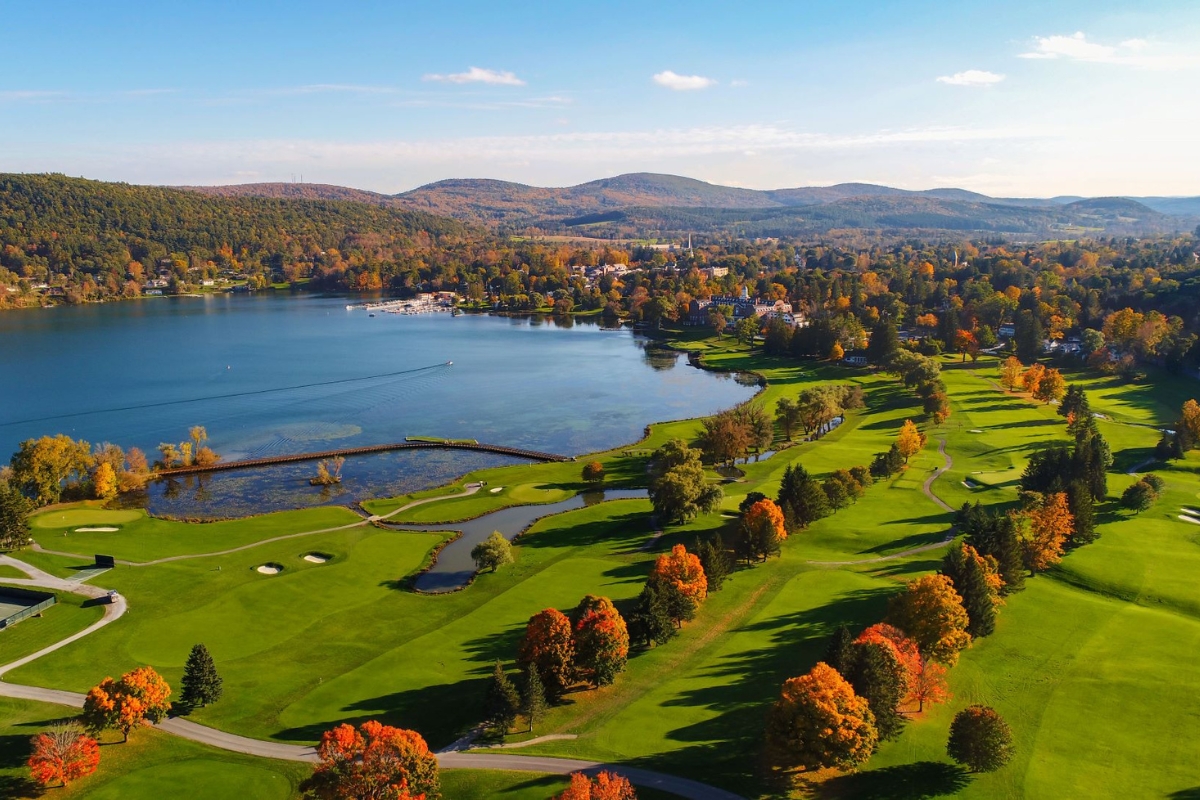 a golf course with a body of water and trees