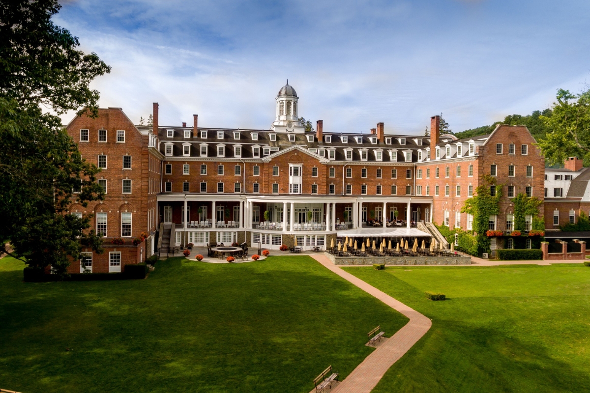 a large brick building with a lawn and a walkway