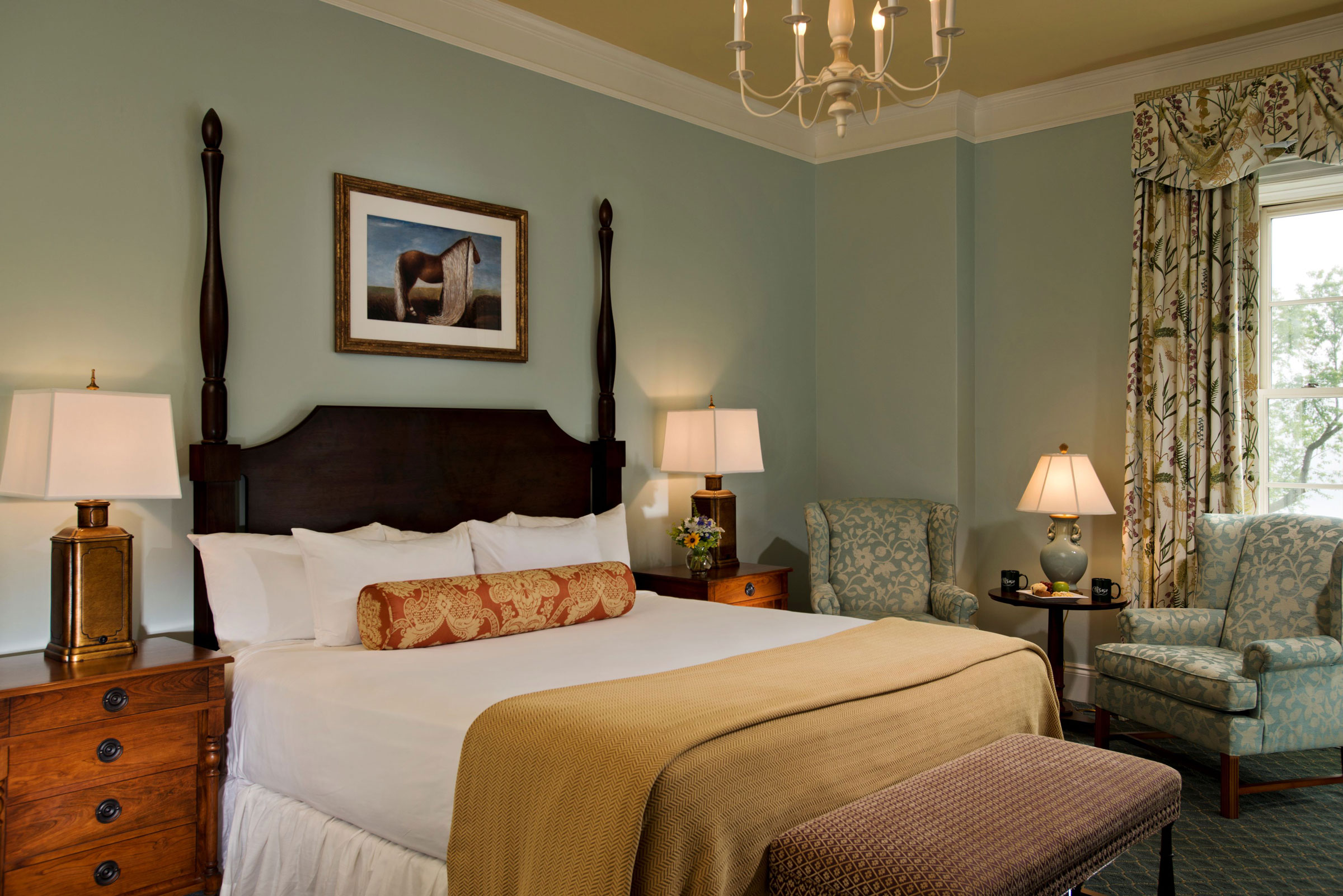 a bedroom with a bed and chairs