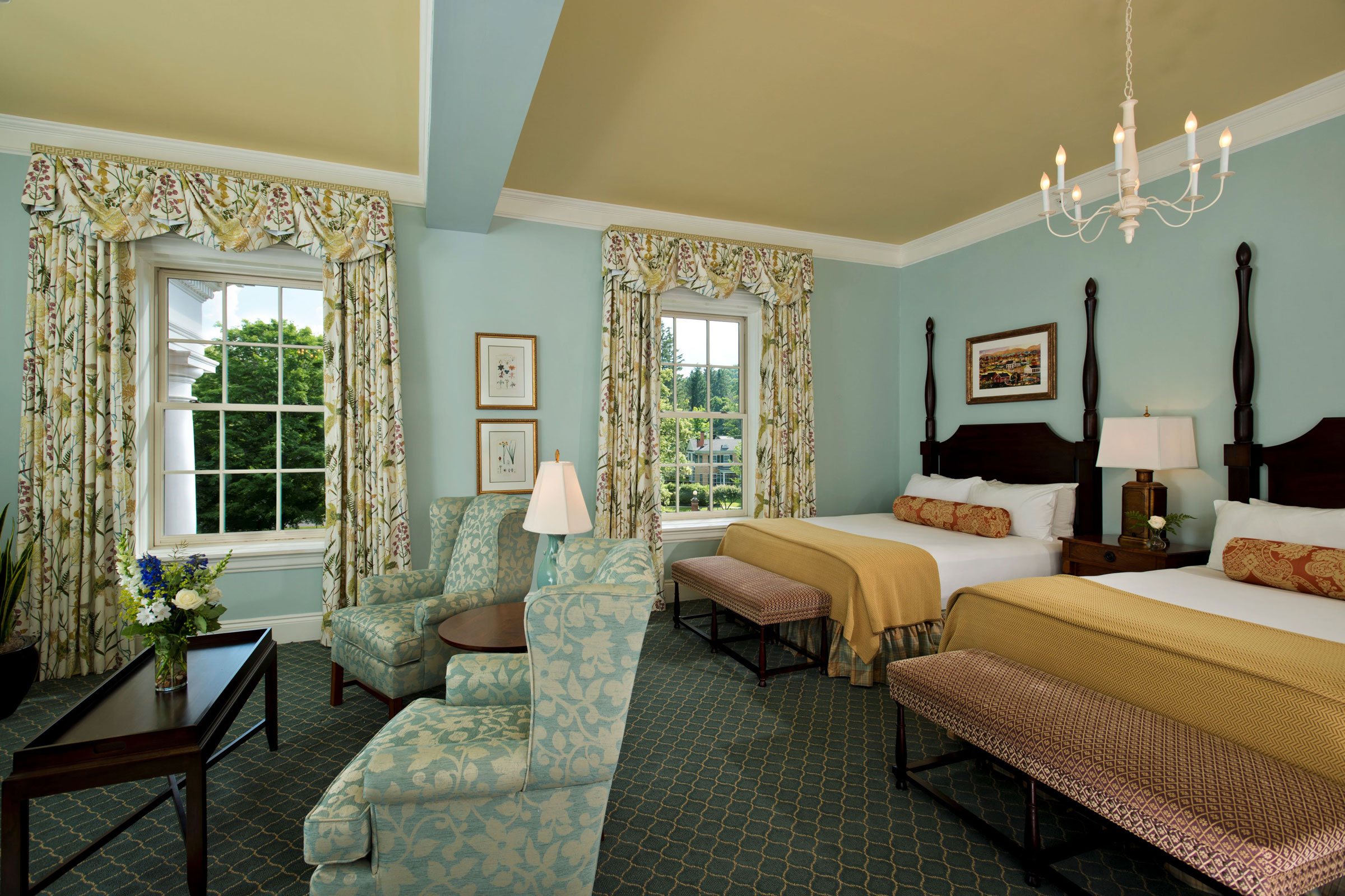 a room with a bed and chairs