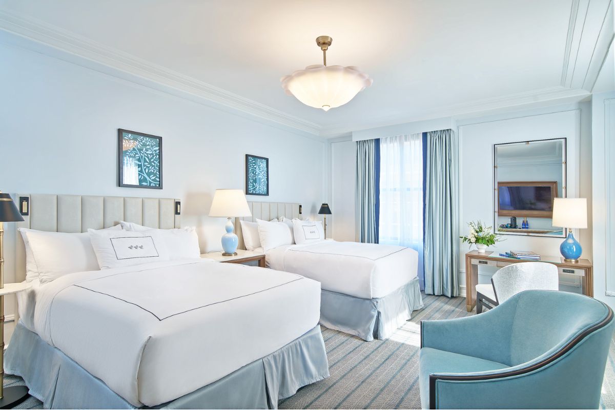 a room with two beds and a lamp