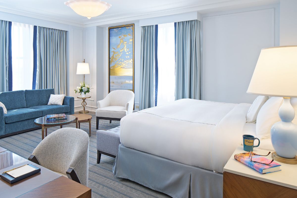 a room with a bed and chairs