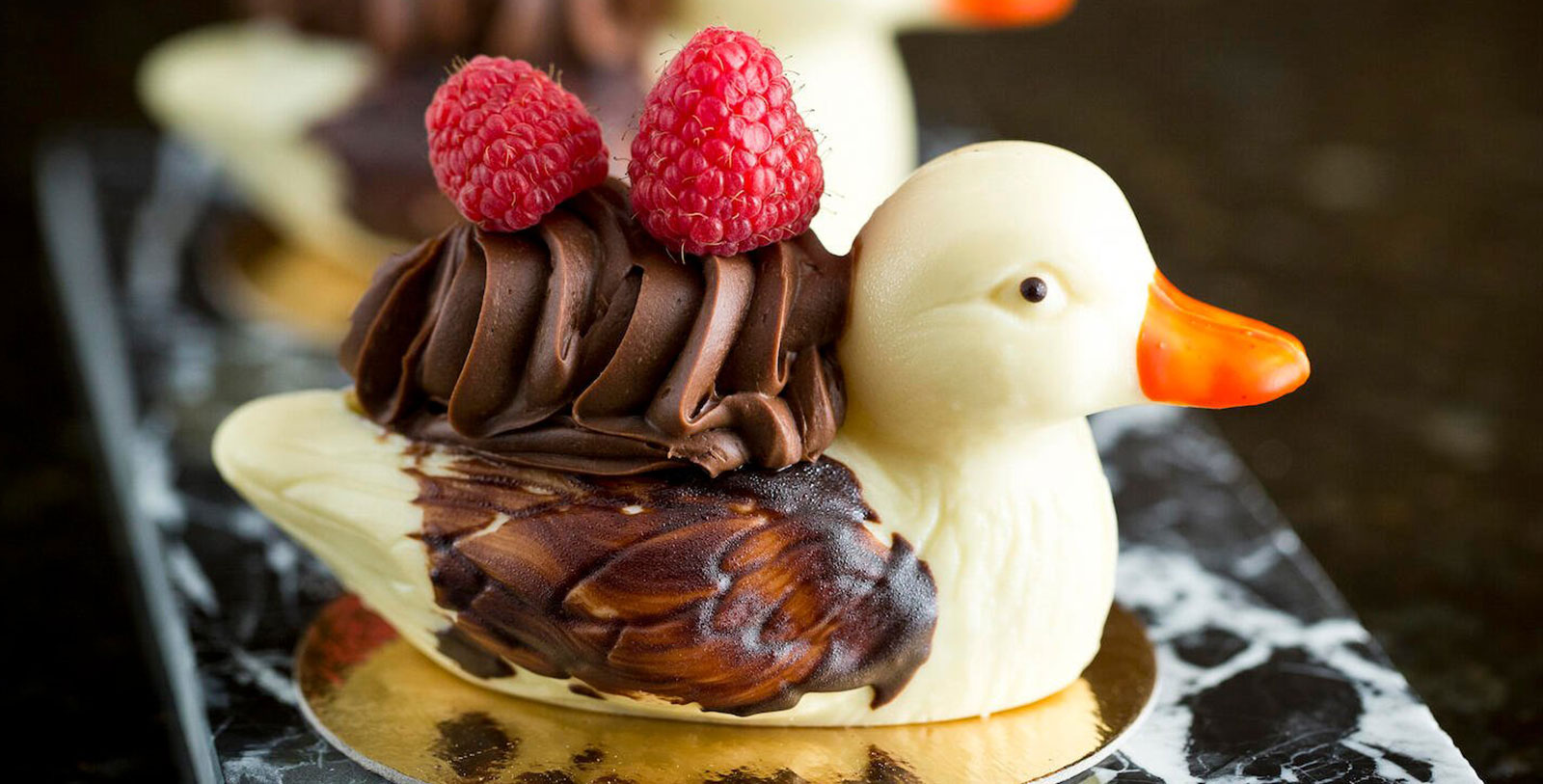 a chocolate duck with raspberries on top
