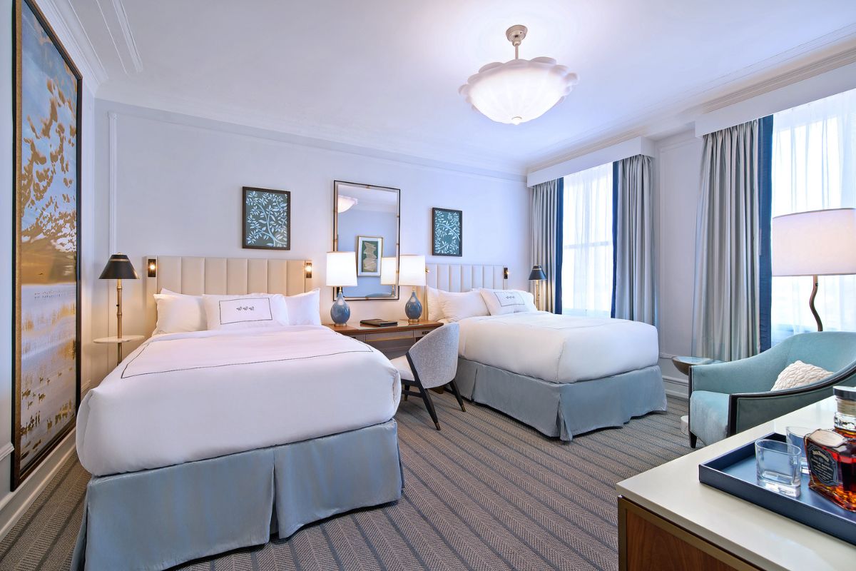 a room with two beds and a lamp