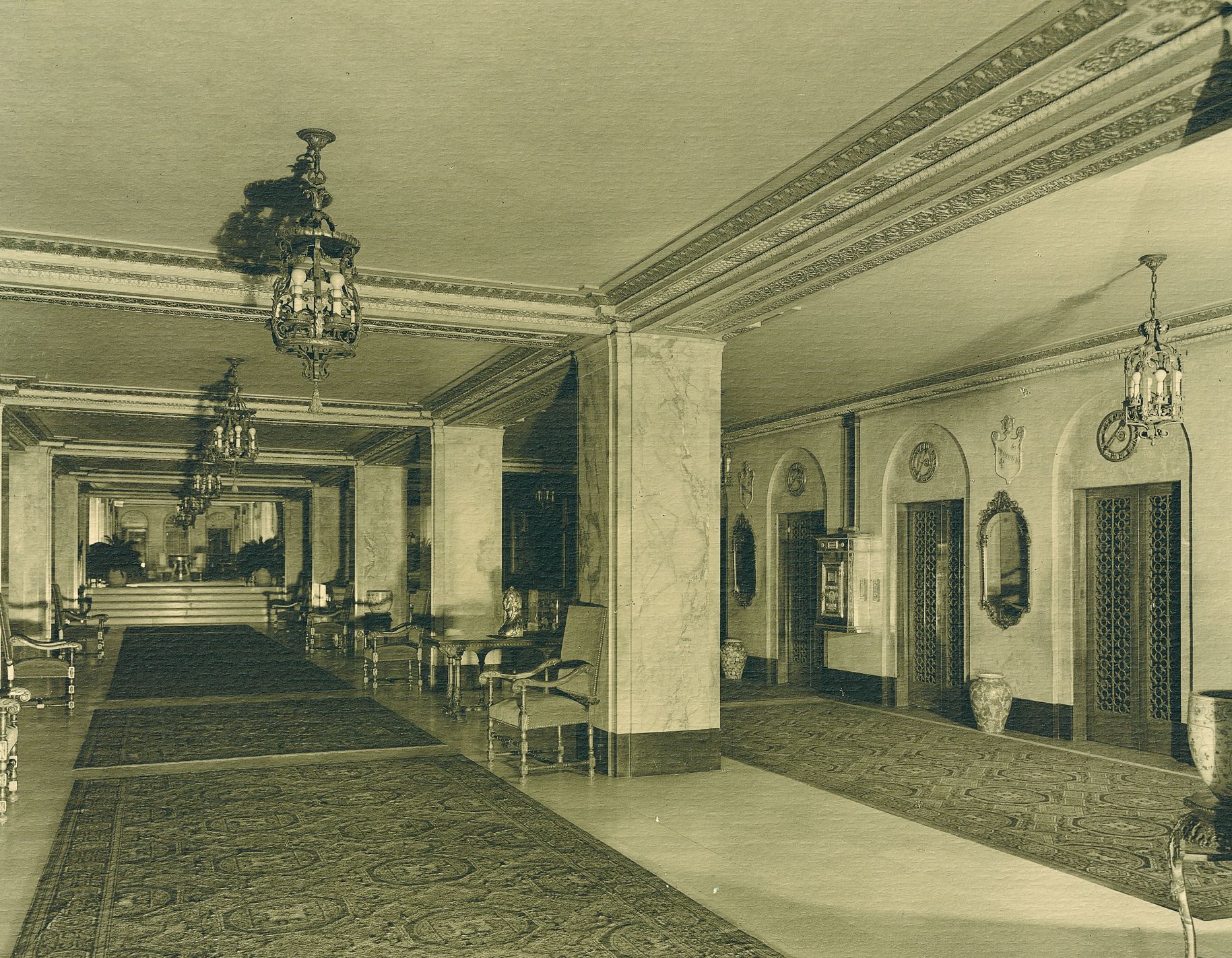 a large hall with a large rug and chandelier