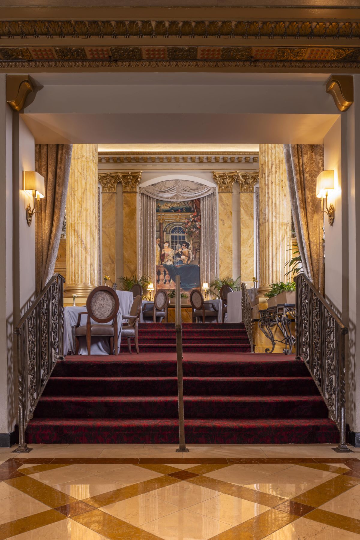a staircase with red carpet and chairs