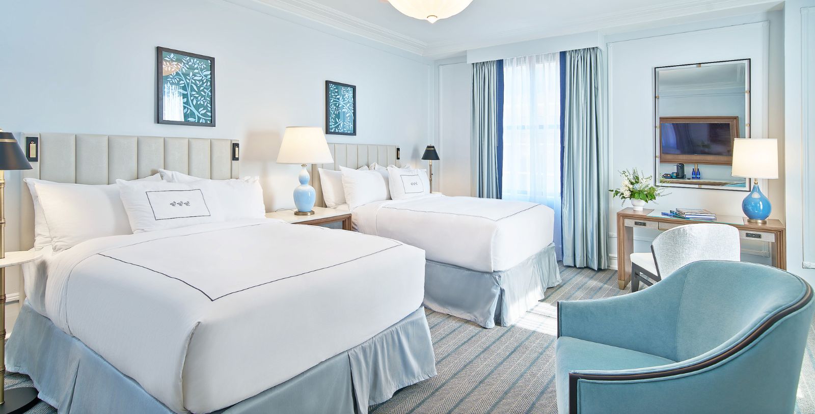 a room with two beds and a chair
